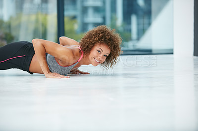 Buy stock photo Shot of a fit young woman doing push-ups in a studio