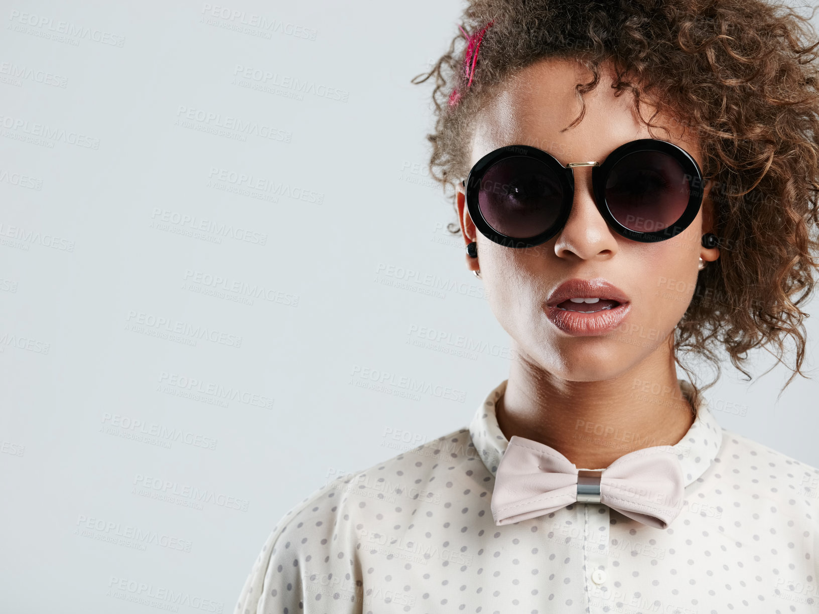 Buy stock photo African woman, fashion sunglasses and studio headshot for makeup, beauty or curly hair afro by gray background. Black woman, dark glasses and edgy portrait for bow tie, trendy aesthetic and confident