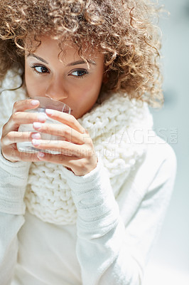 Buy stock photo Shot of a young woman dressed in warm clothing drinking a glass of milk