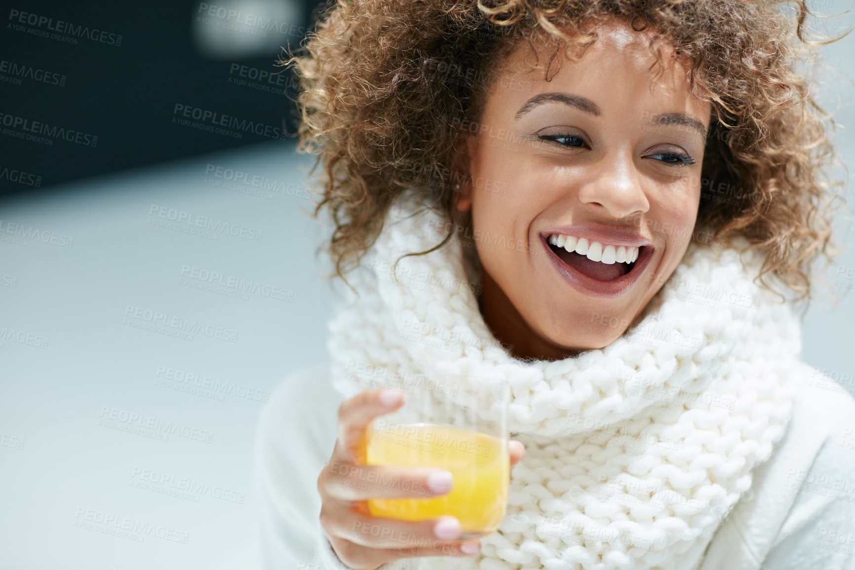 Buy stock photo Shot of a young woman dressed in warm clothing drinking a glass of orange juice