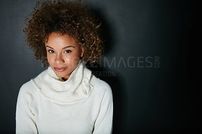 Buy stock photo Studio portrait of an attractive young woman dressed in winter attire against a dark background