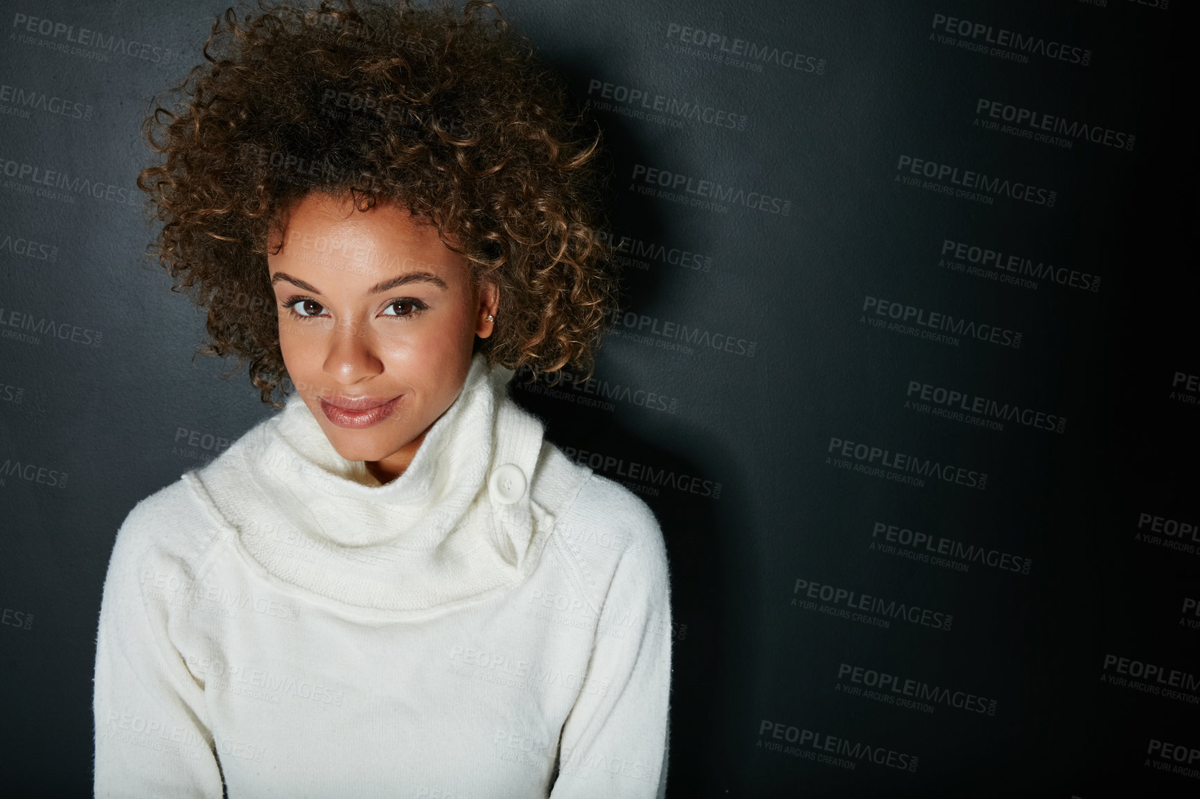 Buy stock photo Studio portrait of an attractive young woman dressed in winter attire against a dark background