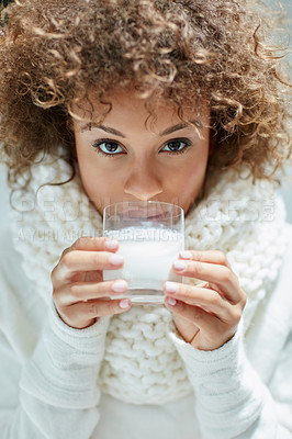 Buy stock photo Portrait of a young woman dressed in warm clothing drinking a glass of milk