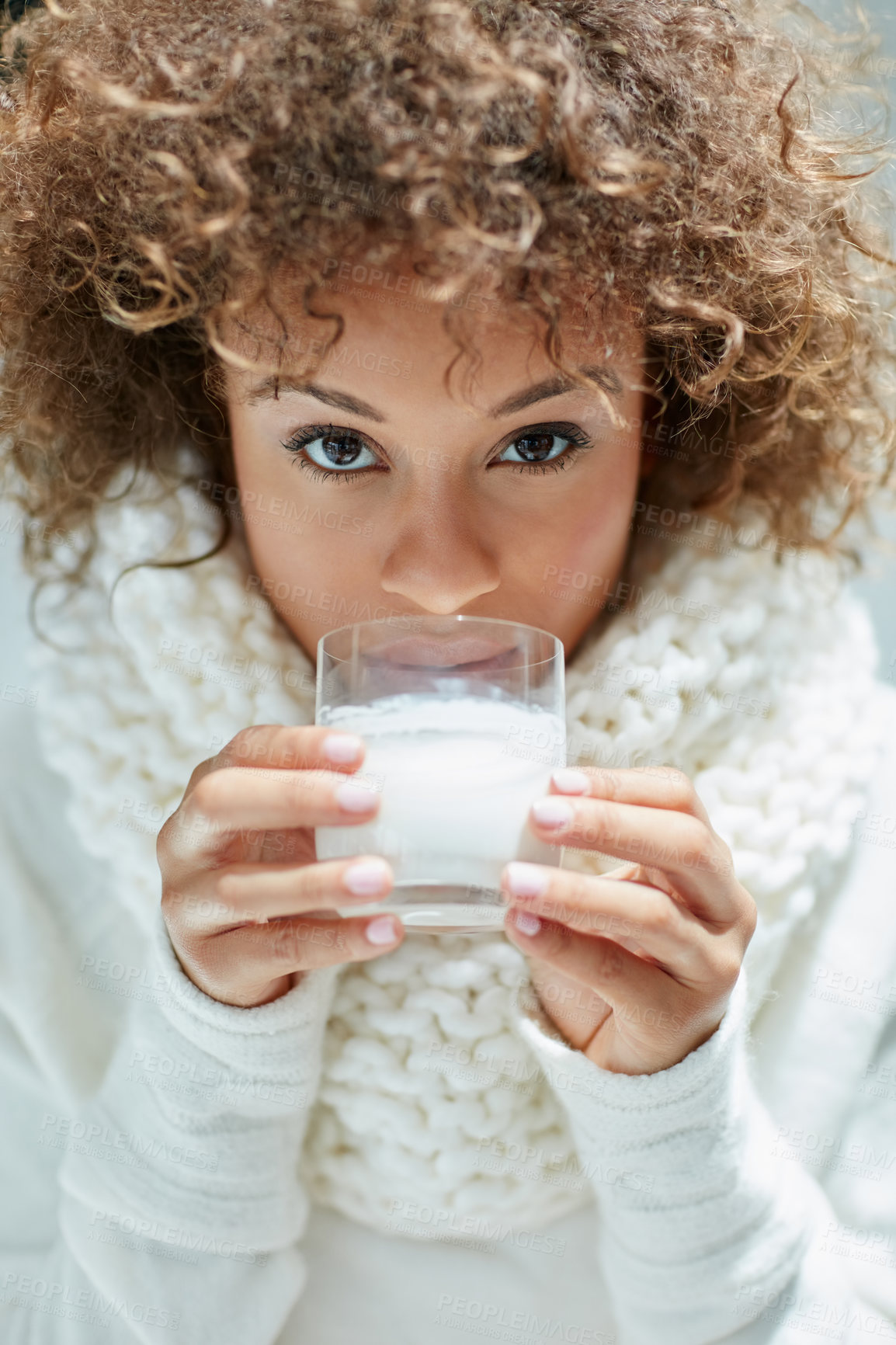 Buy stock photo Portrait of a young woman dressed in warm clothing drinking a glass of milk