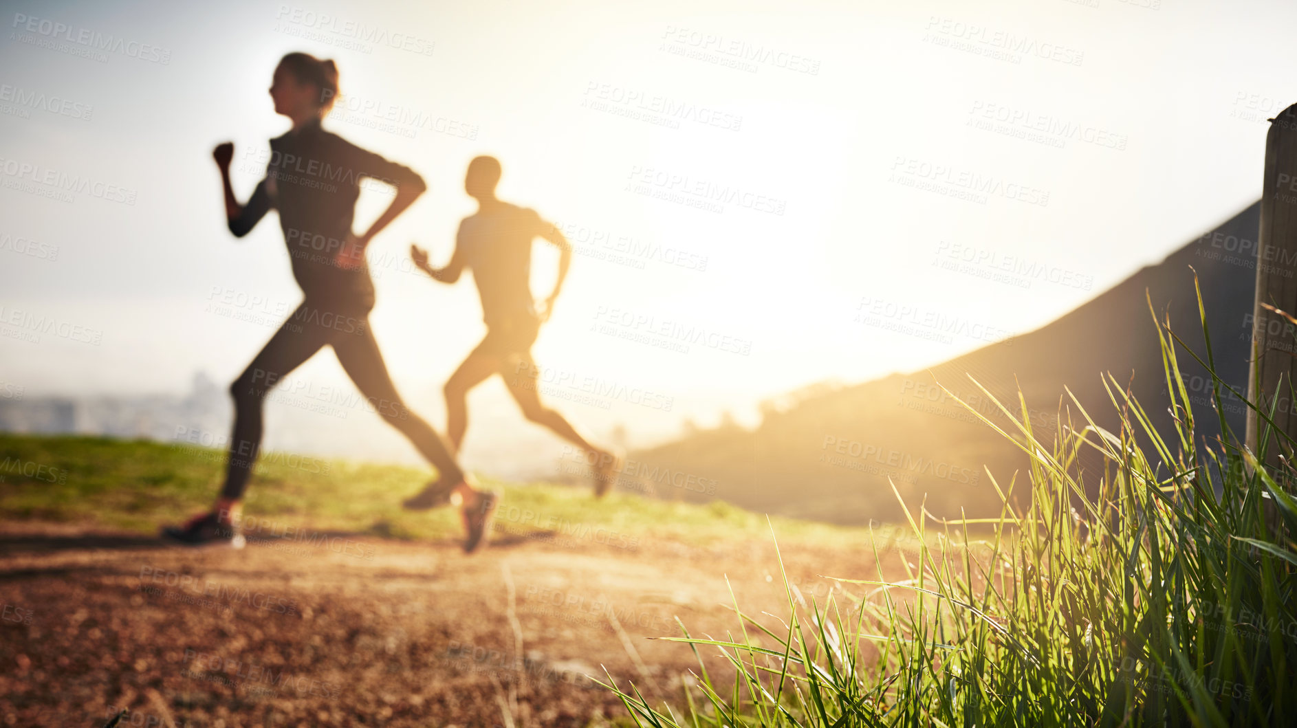 Buy stock photo Shot of a sporty couple out running on a mountain road