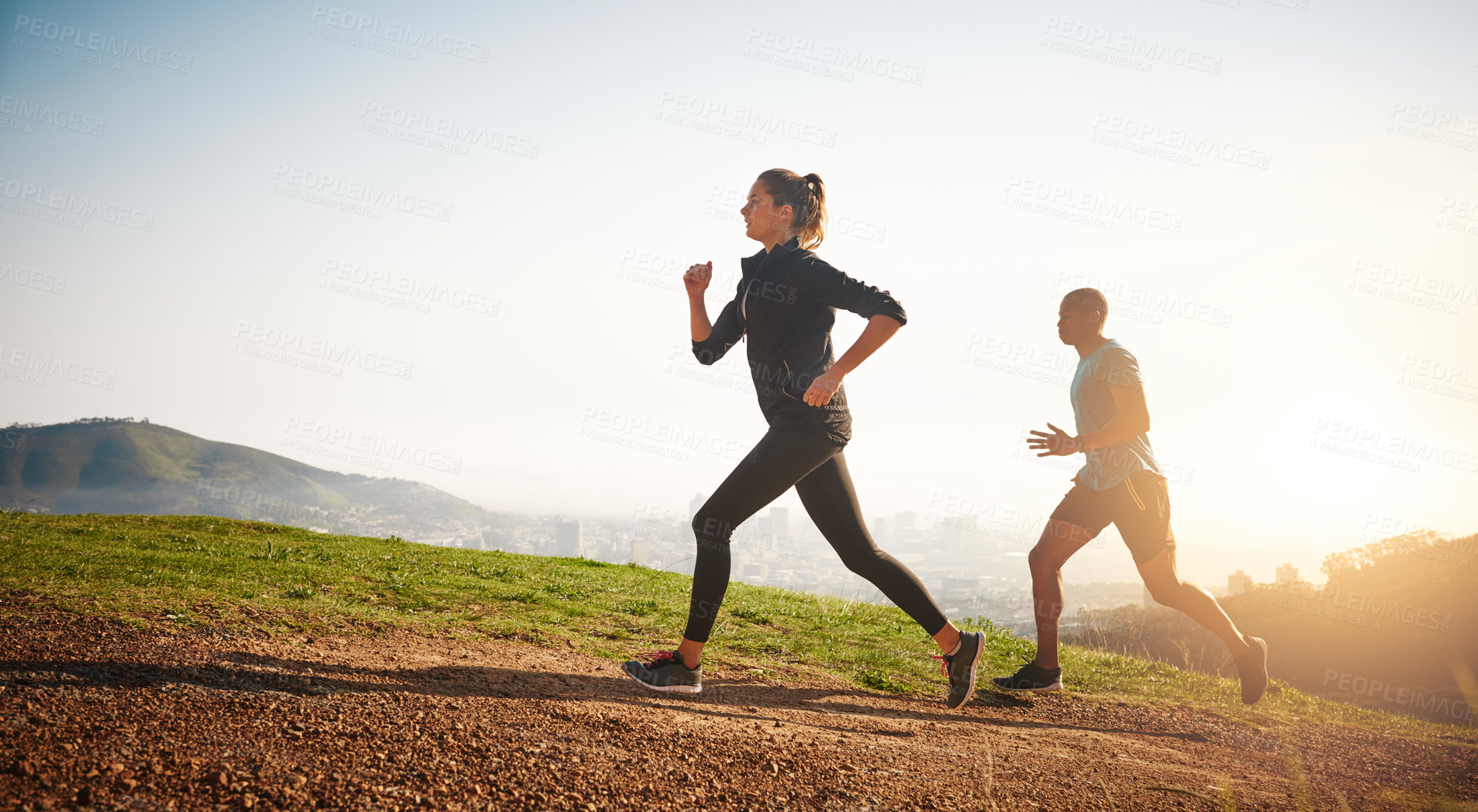 Buy stock photo Shot of a sporty couple out running on a mountain road