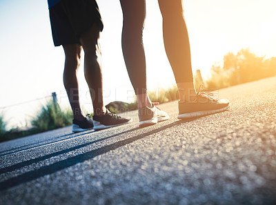 Buy stock photo Cropped shot of two unrecognizable people standing on a tarmac road