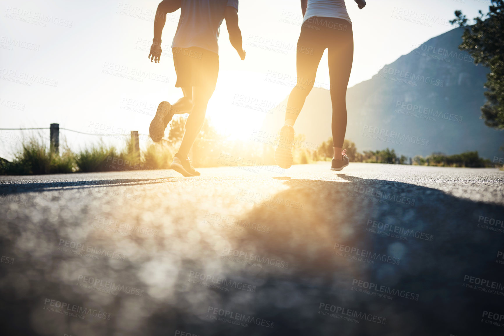 Buy stock photo Fitness, couple and running with legs on mountain road for exercise, workout or outdoor training on asphalt. Active, man and woman with sunshine for sprint, marathon or challenge on street in nature