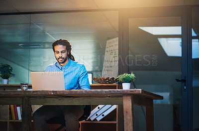 Buy stock photo Cropped shot of a young designer working late on a laptop in an office