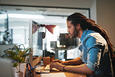 Buy stock photo Cropped shot of a young designer working late on a computer in an office