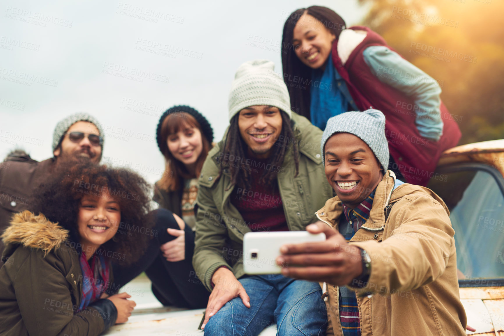 Buy stock photo Shot of a group of friends posing for a selfie while having fun outside
