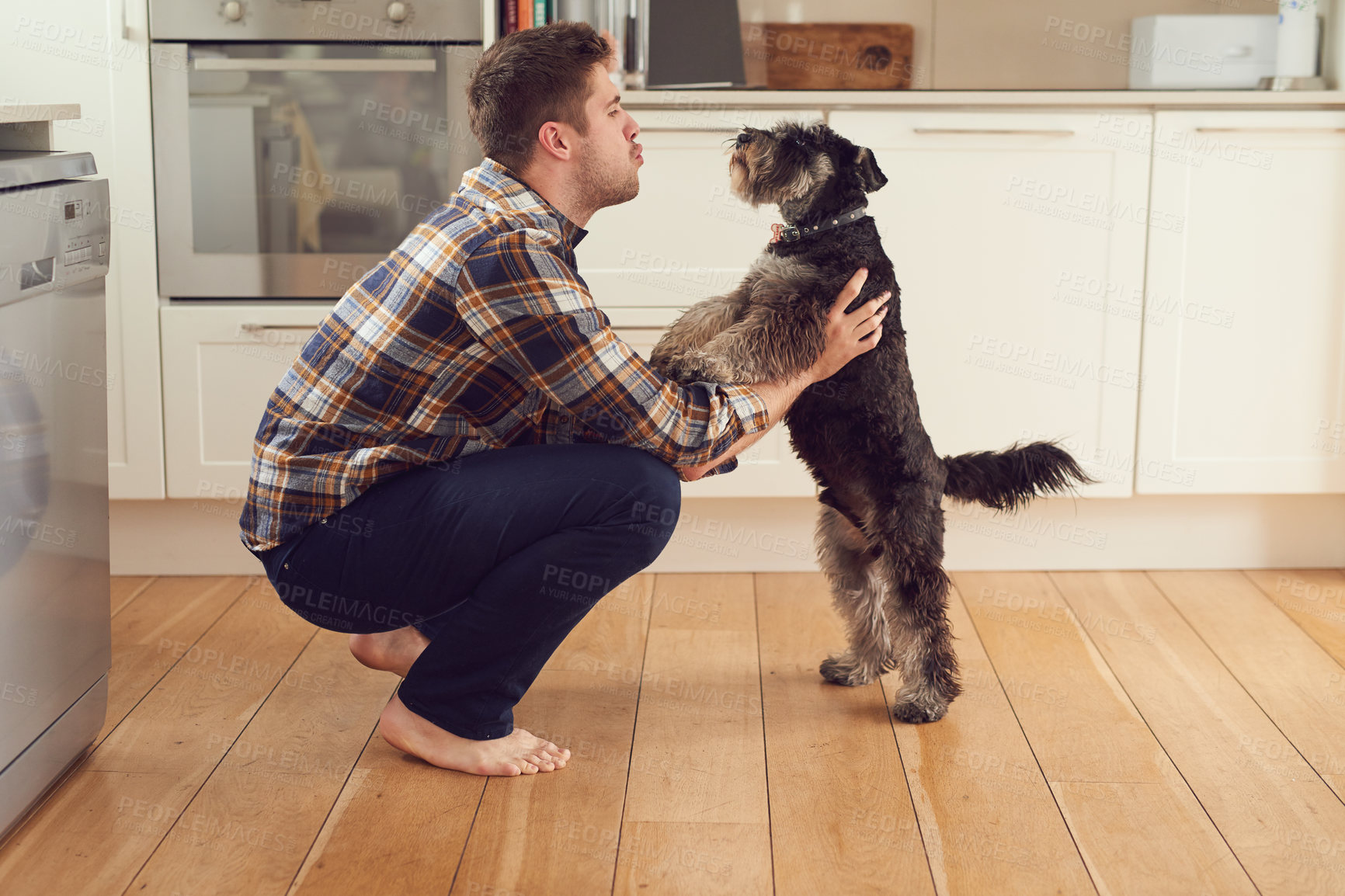 Buy stock photo Shot of a man playing with his dog at home