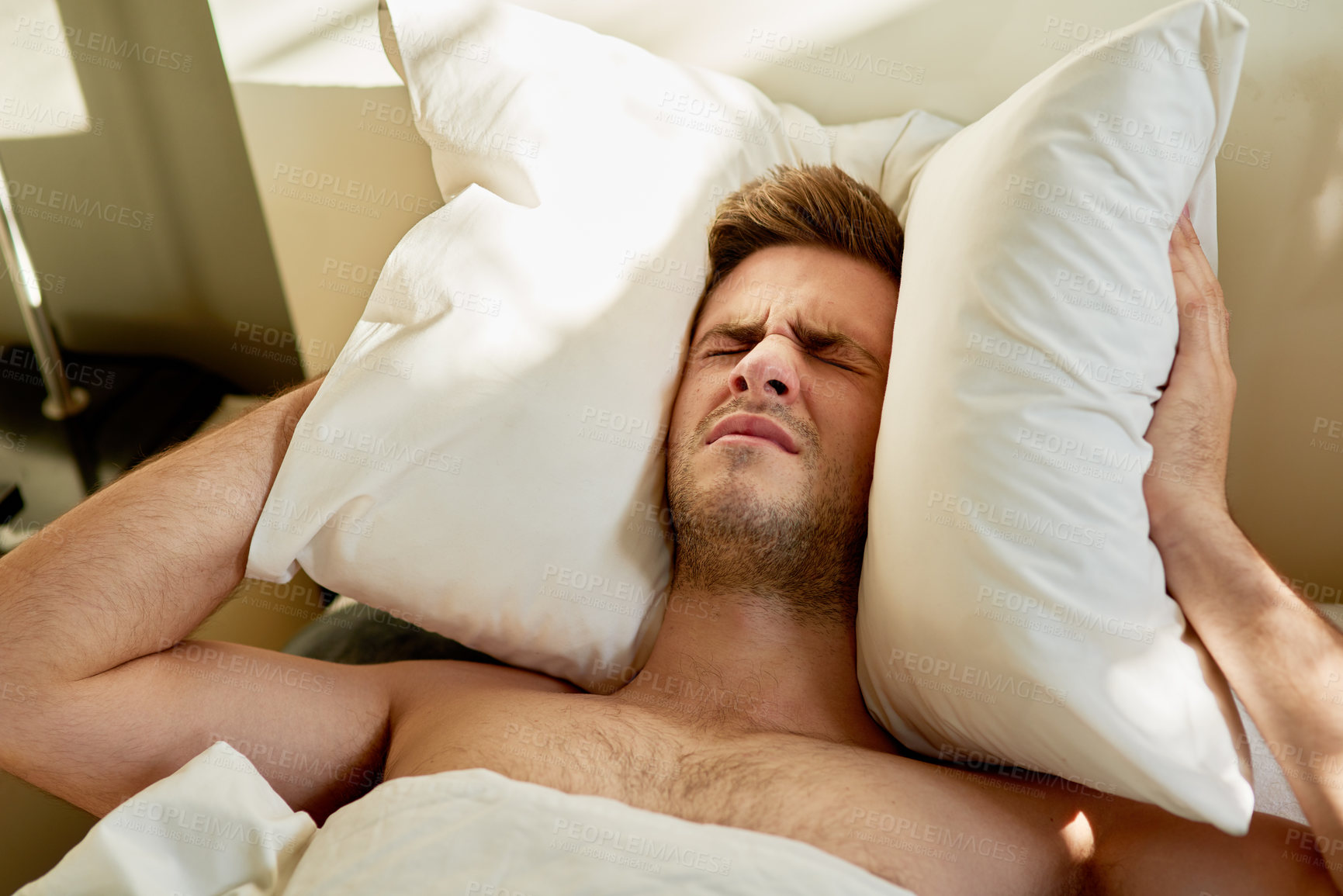 Buy stock photo Man, frustrated and pillow on head in bed on weekend morning for insomnia, depression or mental health issue. Male person, sleepless and tired in apartment for headache, anxiety and noise at home