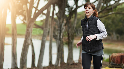 Buy stock photo Shot of a healthy young woman out for a run in nature