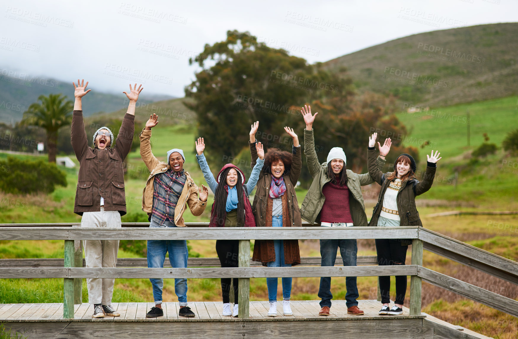 Buy stock photo Group, holiday and happy people on pier with hands up for outdoor winter adventure in nature. Fun, celebration and excited friends on dock together for camping vacation, bonding and relax at lake.