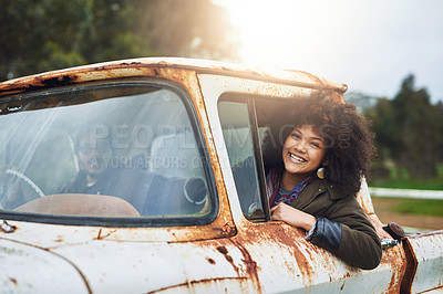 Buy stock photo Shot of a happy young woman sitting in a rusty old truck