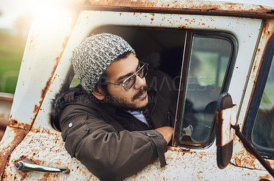 Buy stock photo Shot of a happy young man sitting in a rusty old truck