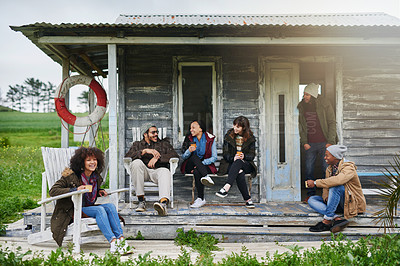 Buy stock photo Shot of a group of friends relaxing on the porch of a fishing cabin on a weekend getaway