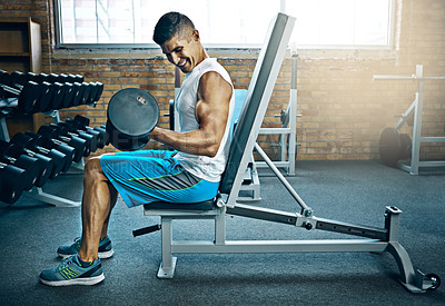 Buy stock photo Shot of a young man working out alone in the gym