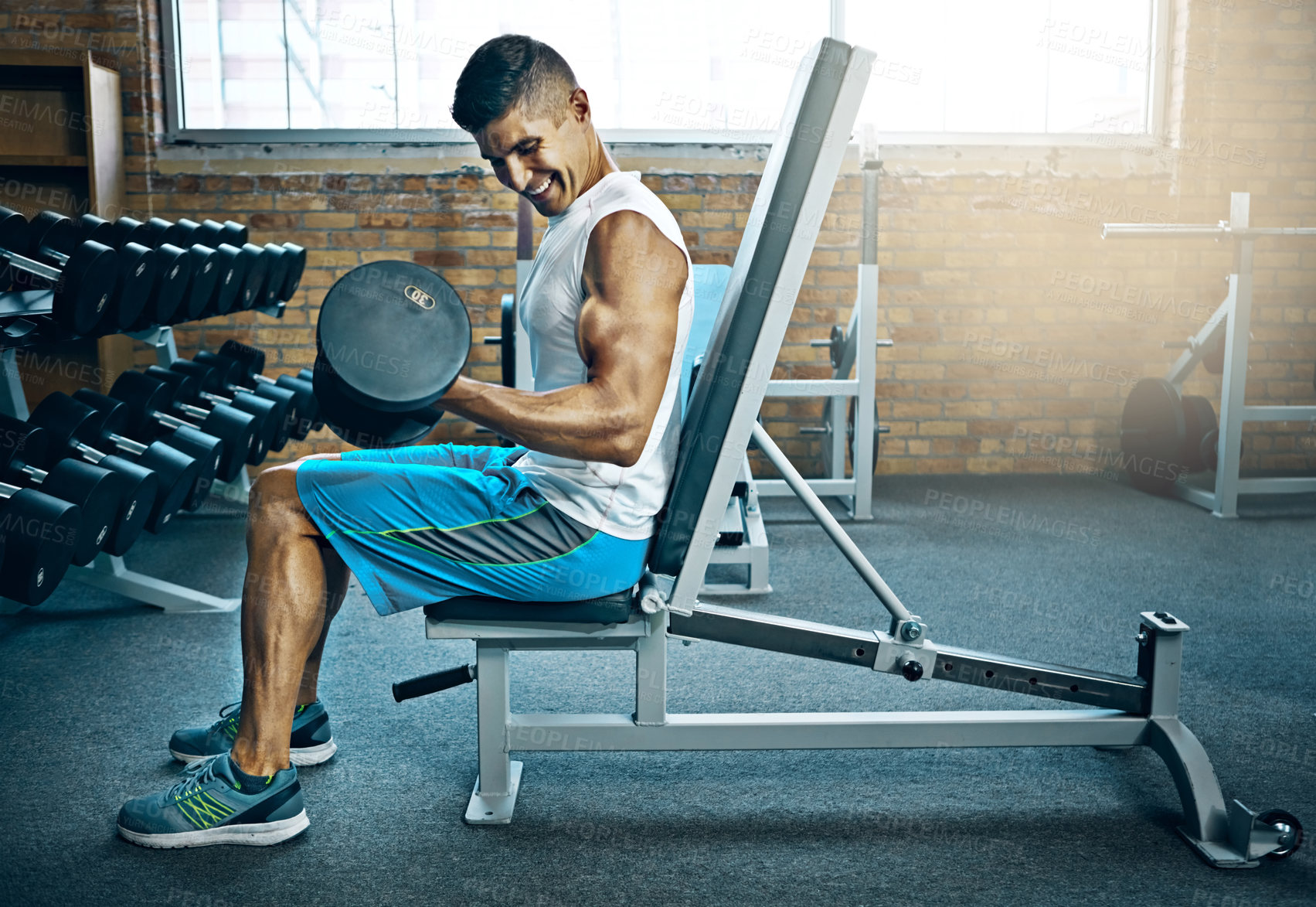 Buy stock photo Shot of a young man working out alone in the gym