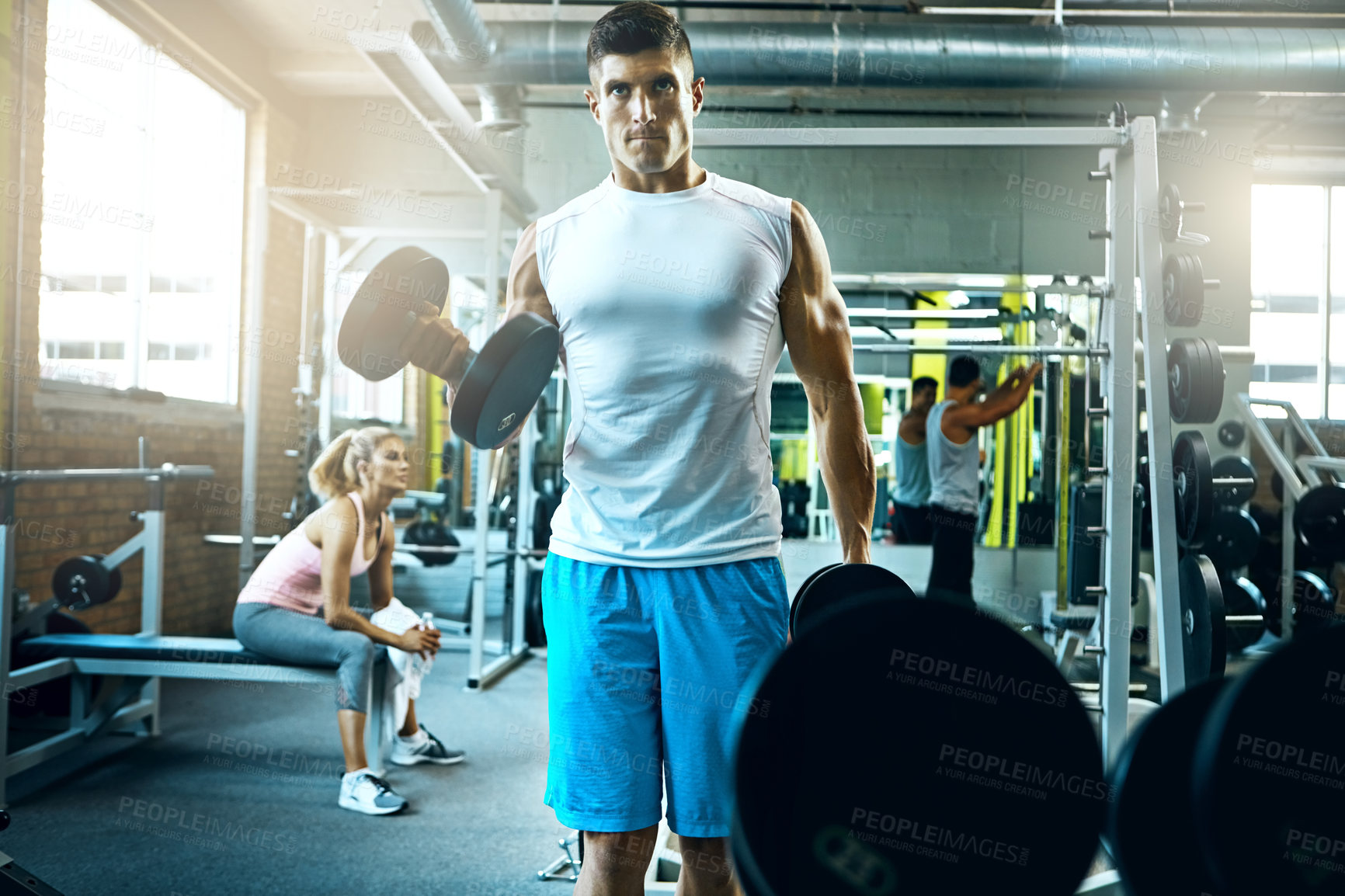 Buy stock photo Shot of a young man working out alone in the gym