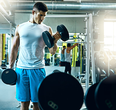 Buy stock photo Shot of a young man working out alone in the gym