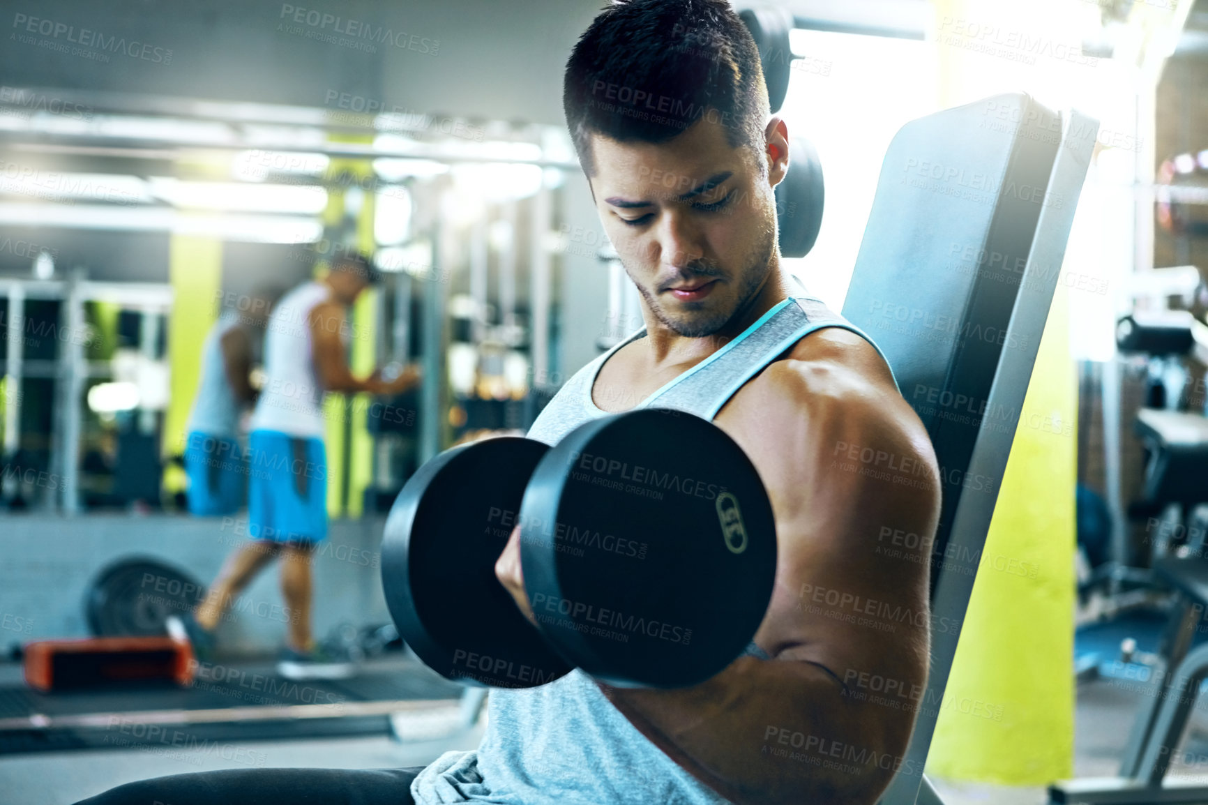 Buy stock photo Shot of a man doing a upper-body workout at the gym