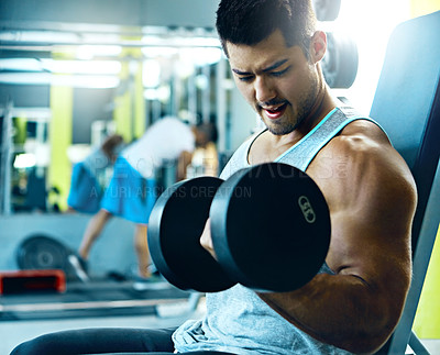 Buy stock photo Shot of a man doing a upper-body workout at the gym