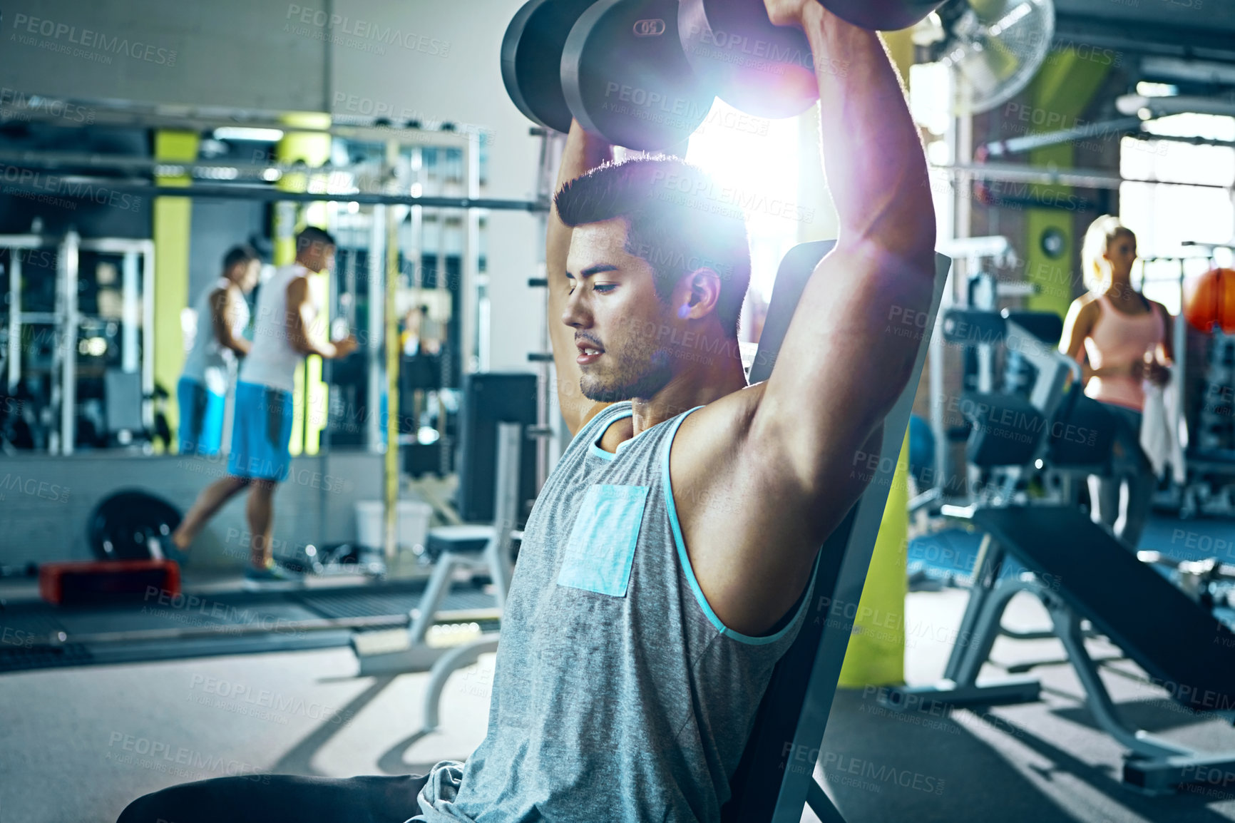 Buy stock photo Shot of a man doing a upper-body workout at the gym