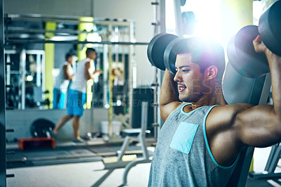 Buy stock photo Shot of a man doing a upper-body workout at the gym