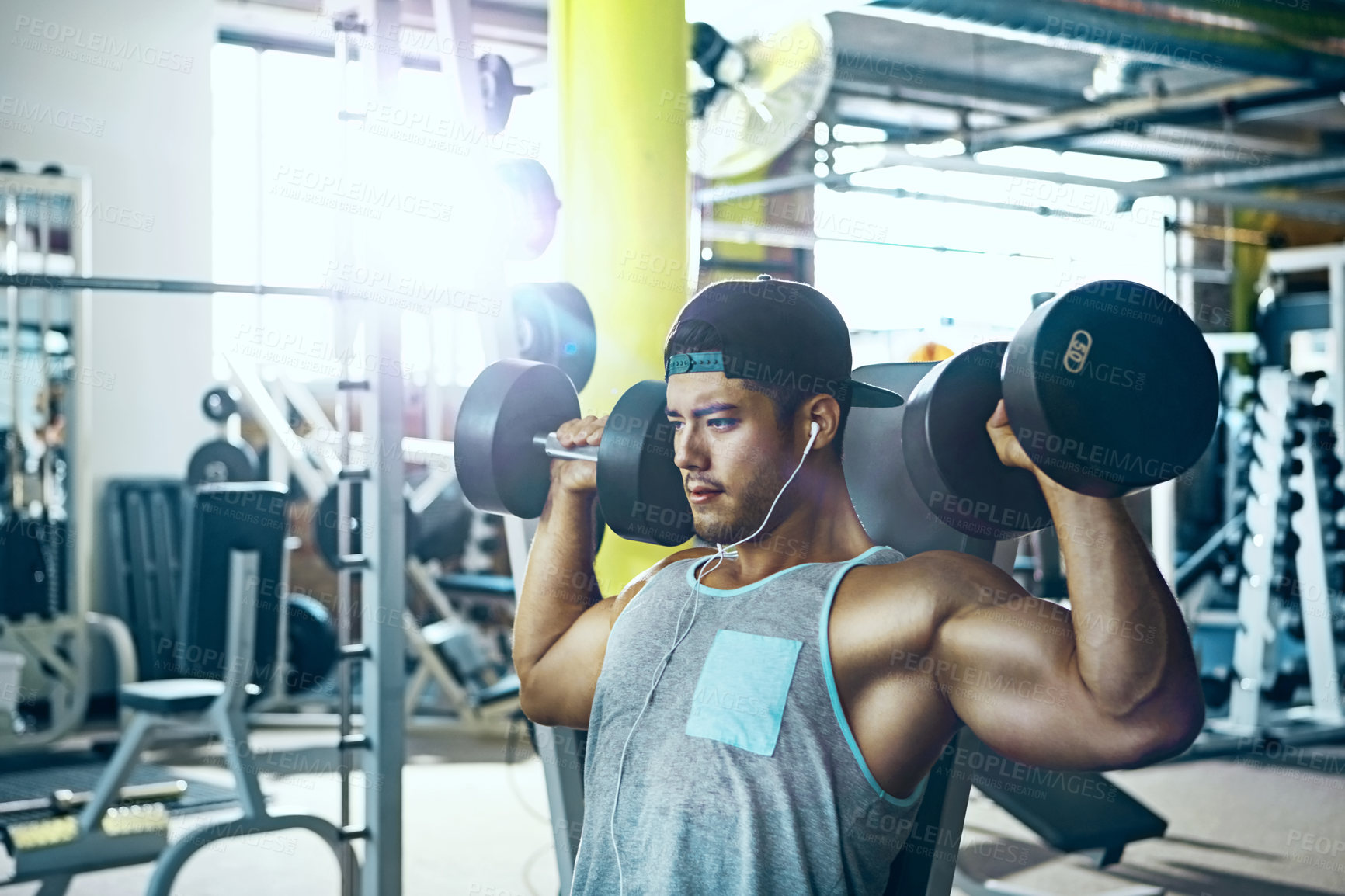 Buy stock photo Shot of a man doing a upper-body workout at the gym