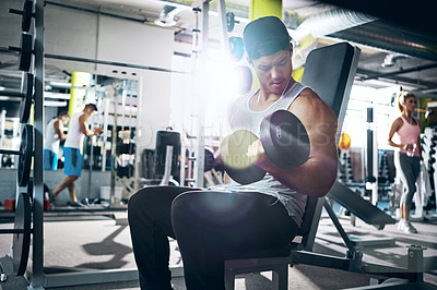 Buy stock photo Shot of a man doing a upper-body workout at the gym