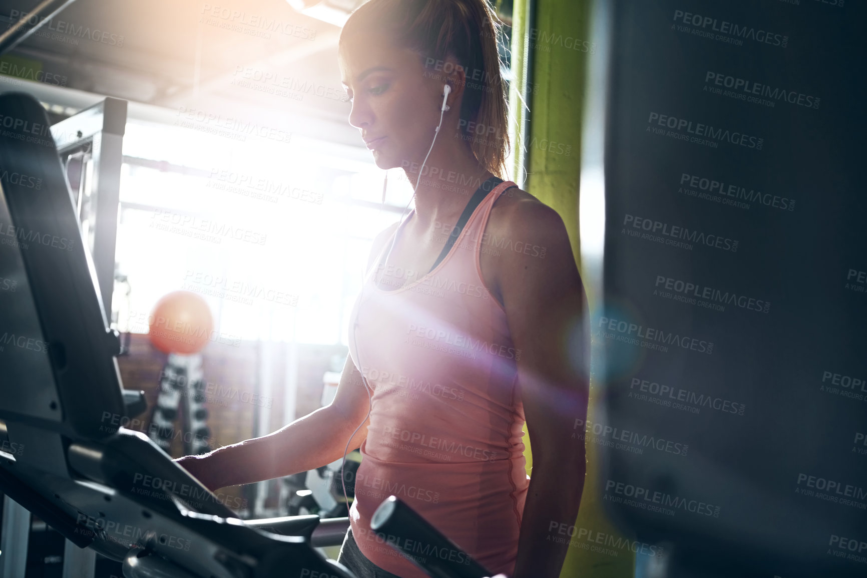 Buy stock photo Shot of a young woman on the treadmill at the gym