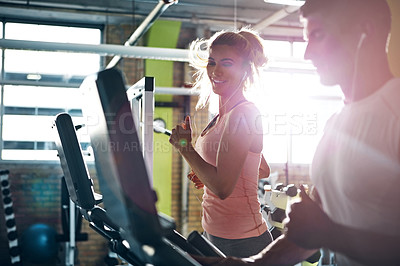 Buy stock photo Shot of a man and a woman working out together in the gym