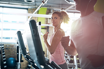 Buy stock photo Shot of a man and a woman working out together in the gym