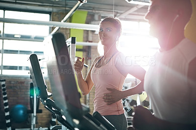 Buy stock photo Shot of a man and a woman working out together in the gym