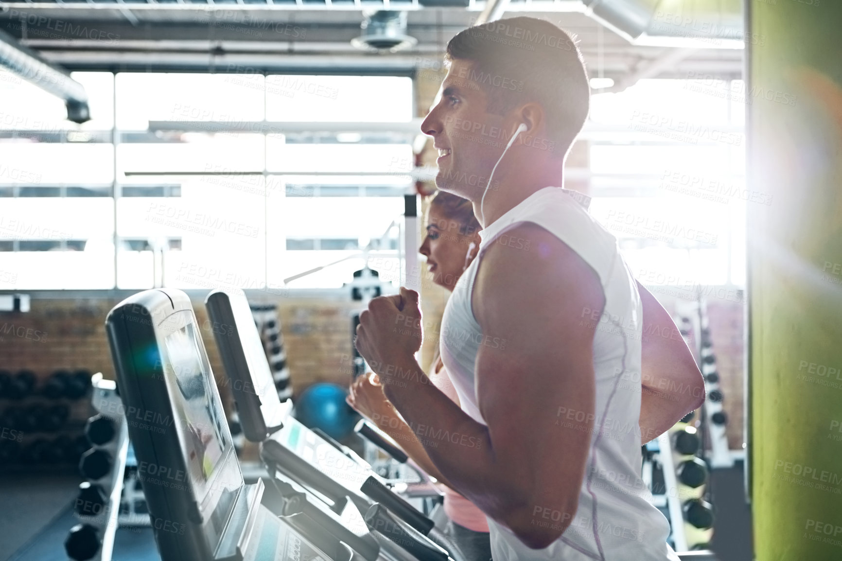 Buy stock photo Shot of a man and a woman working out together in the gym