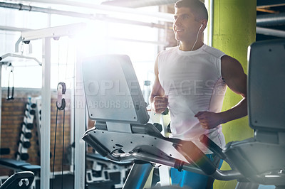 Buy stock photo Shot of a young man working out alone in the gym