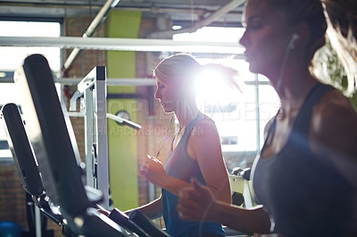 Buy stock photo Shot of two women on the treadmill at the gym