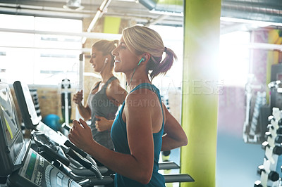 Buy stock photo Shot of two women on the treadmill at the gym