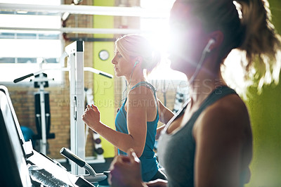 Buy stock photo Shot of two women on the treadmill at the gym