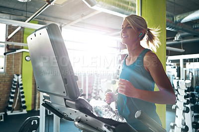 Buy stock photo Shot of a young woman working out on the treadmill at the gym