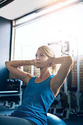 Buy stock photo Shot of a sporty woman doing sit-ups at the gym