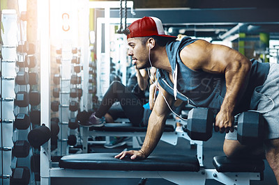 Buy stock photo Shot of a young man working out alone in the gym