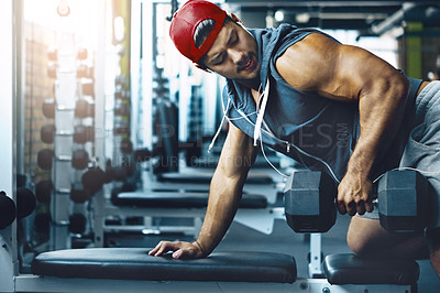 Buy stock photo Shot of a young man working out alone in the gym