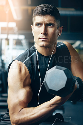 Buy stock photo Shot of a young man working out alone in the gym