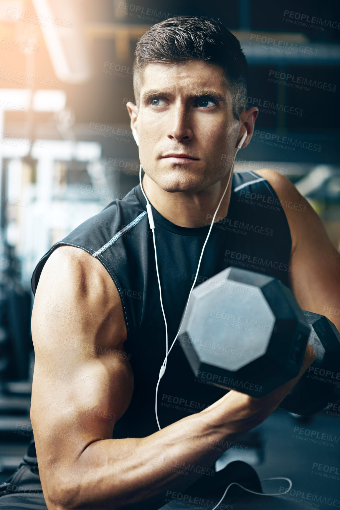 Buy stock photo Shot of a young man working out alone in the gym