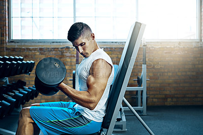 Buy stock photo Shot of a man doing a upper-body workout at the gym