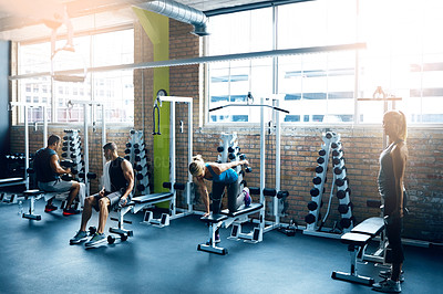 Buy stock photo Shot of a group of people working out in the gym