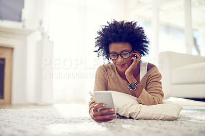 Buy stock photo Shot of a young woman using her phone at home